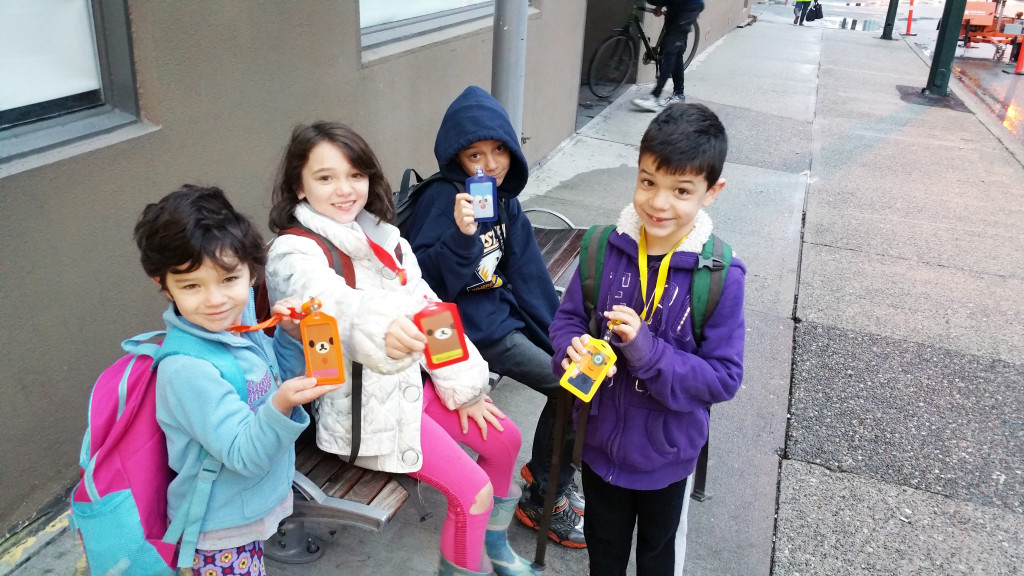 The kids proudly display their Compass cards (transit passes) on our first official day of car-free living.
